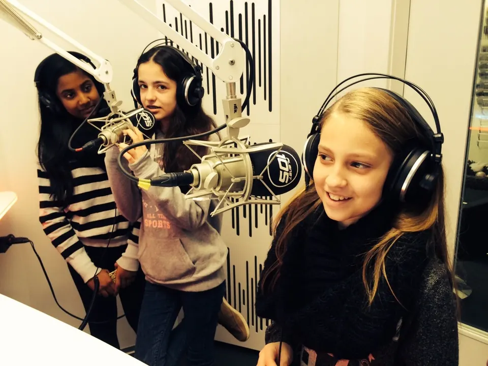 Ein Mädchen mit Kopfhörern beim Besuch im Radiostudio