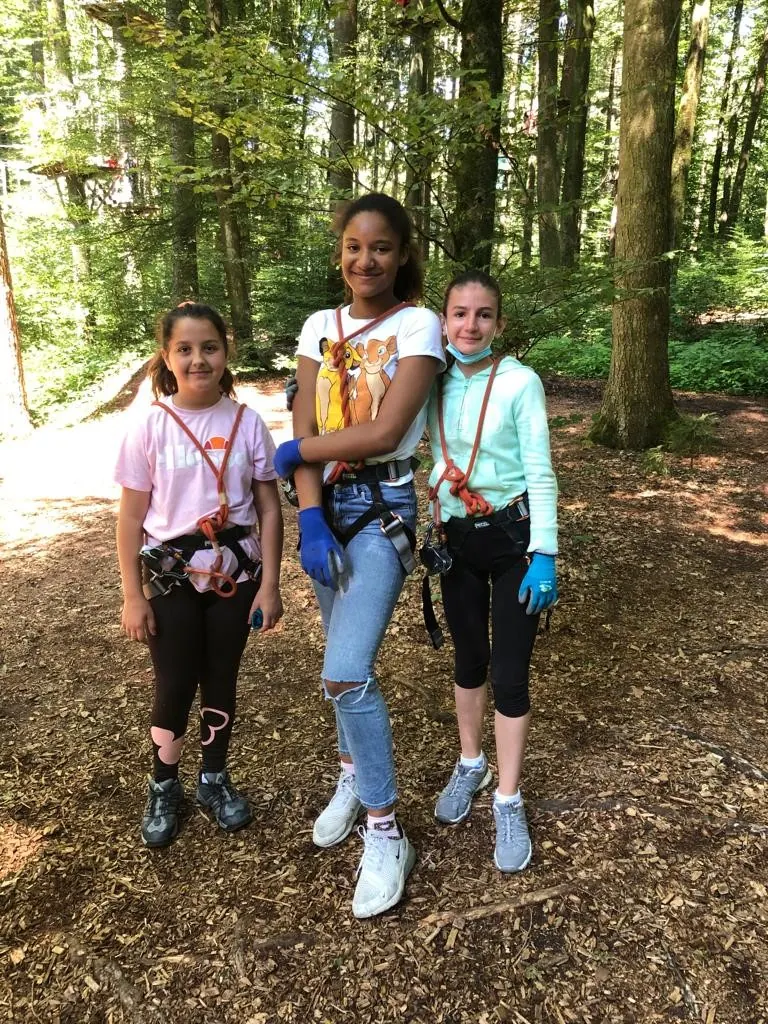 Drei Mädchen in Kletterausrüstung im Seilpark Zürich